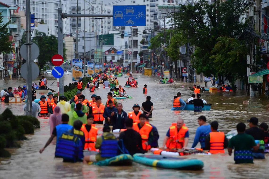 11月20日，越南庆和省芽庄市遭暴雨袭击，人们正在洪水中跋涉。（法新社）