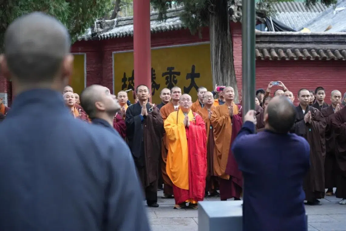 河南嵩山少林寺在中国国庆当日举行升旗仪式。方丈释永信（居中）身穿袈裟带领众僧祈祷。（少林寺官网）