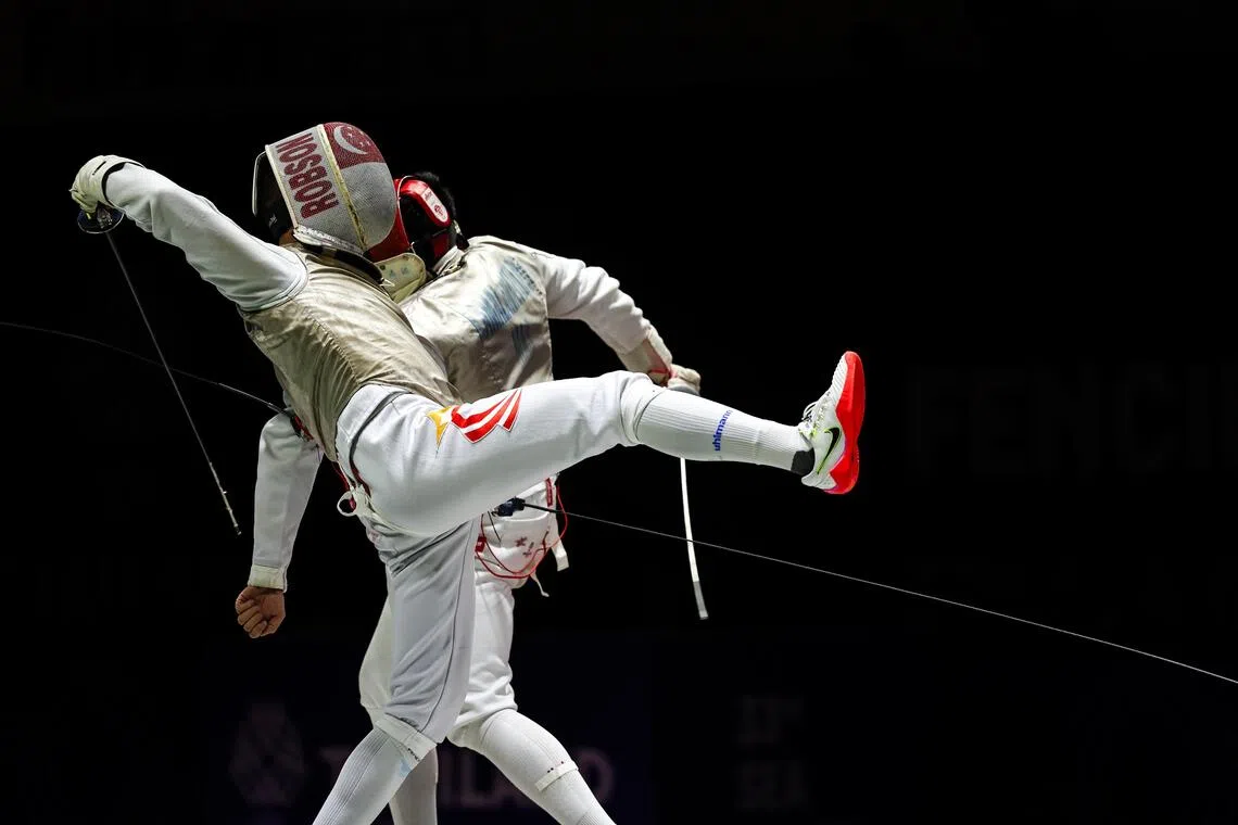 我国击剑选手晨阳（左）在比赛中对垒马来西亚选手时，敏捷闪躲对方的攻势。（白艳琳摄）