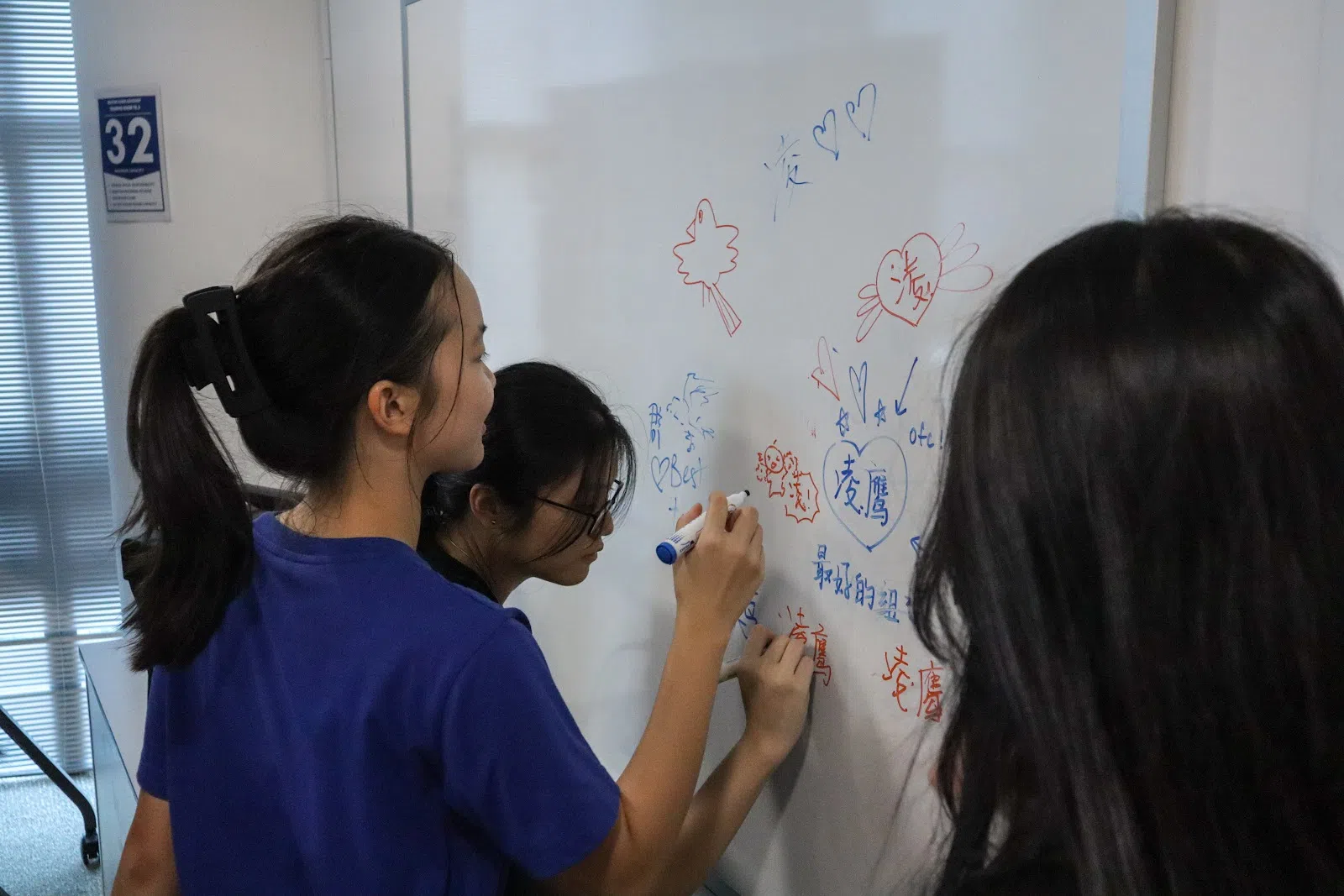 迎新当天便渐渐对自己的鹰组有了归属感的凌鹰组新鹰（实习通讯员），在白板上写下对凌鹰组的喜爱。（联合学生摄影通讯员詹歆仪摄）