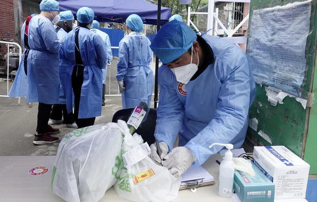 北京前天（26日）展开了自疫情暴发以来最大规模的全员核酸检测。图为朝阳区工作人员负责发放物资。（新华社）