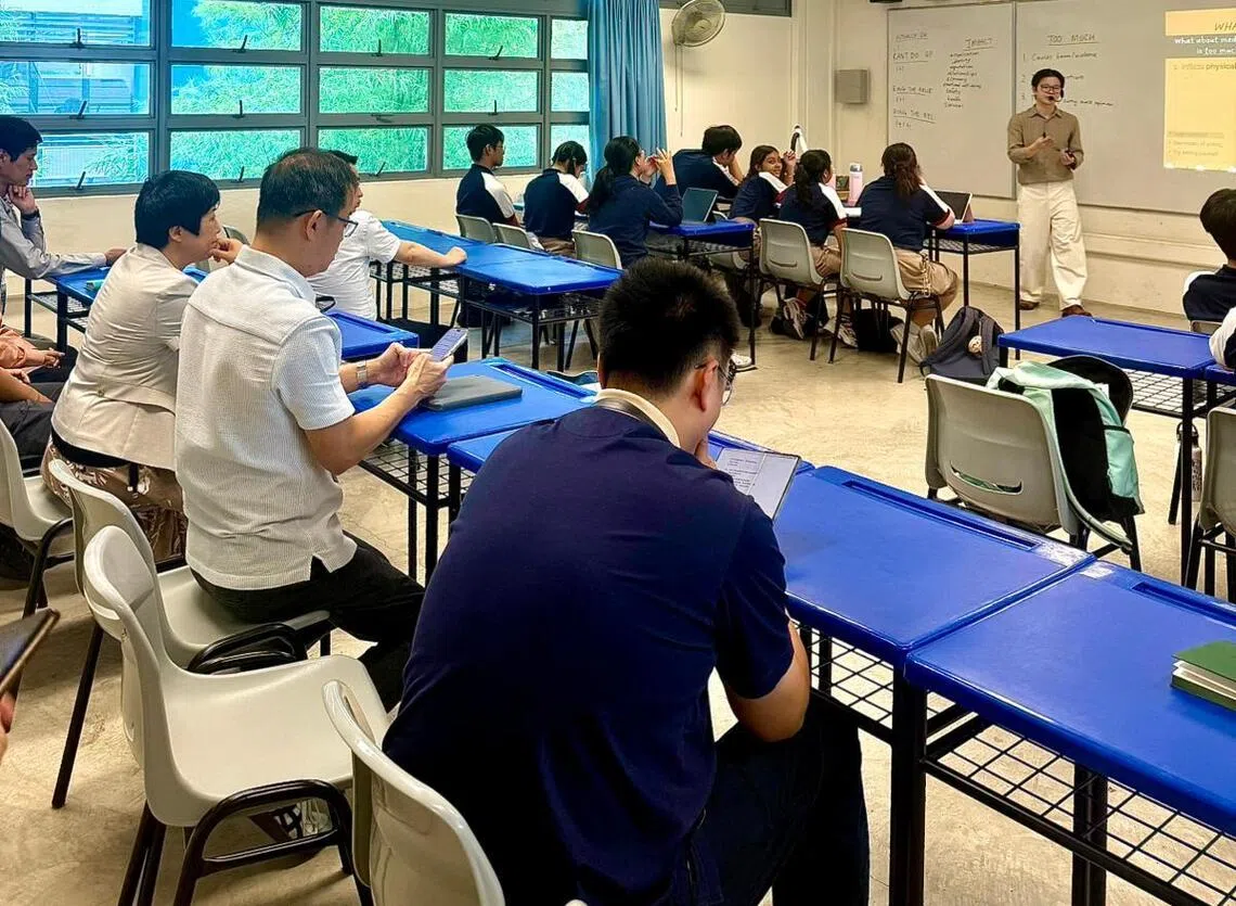 访问团观摩英文教师林琨亮（站立者）引导学生思考的课堂教学过程。（淡滨尼美廉初级学院提供）