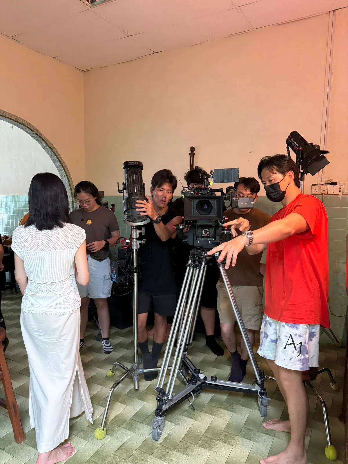 戚玉武（右一红衣者）在片场指导欧菁仙（左一白旗袍者）演戏。（受访者提供）