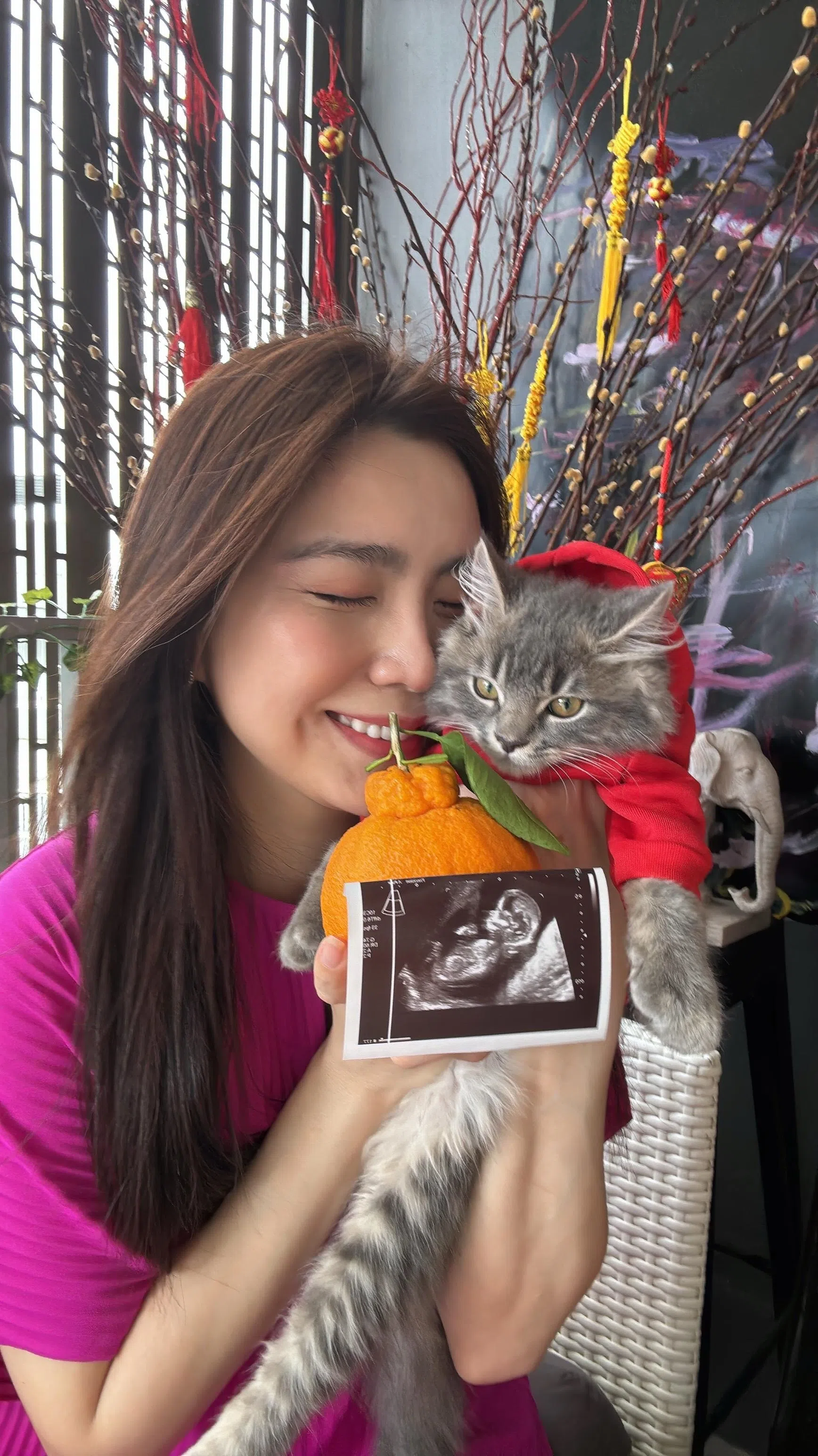 马艺瑄抱着爱猫Lucky秀出肚中宝宝的超声波图片。（受访者提供）