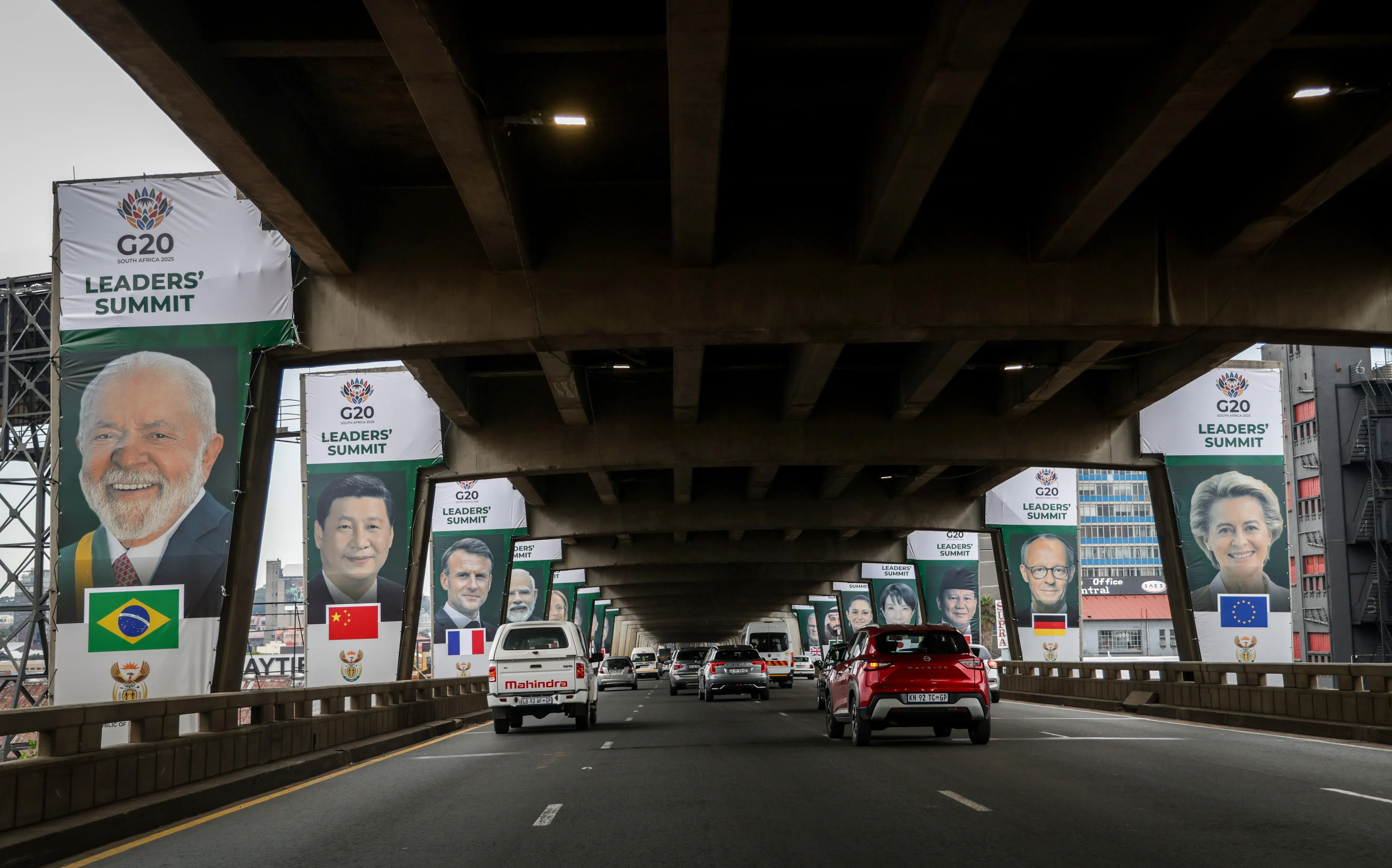 首次举行二十国集团会议的约翰内斯堡，在公路两旁挂上醒目的集团成员国领导人旗子，例如巴西总统卢拉（左一）、中国国家主席习近平（左二）、法国马克龙（左三）、欧盟委员会主席冯德莱恩（右一）、德国总理默茨（右二）和印度尼西亚总统普拉博沃（右三）等。（叶振忠摄）