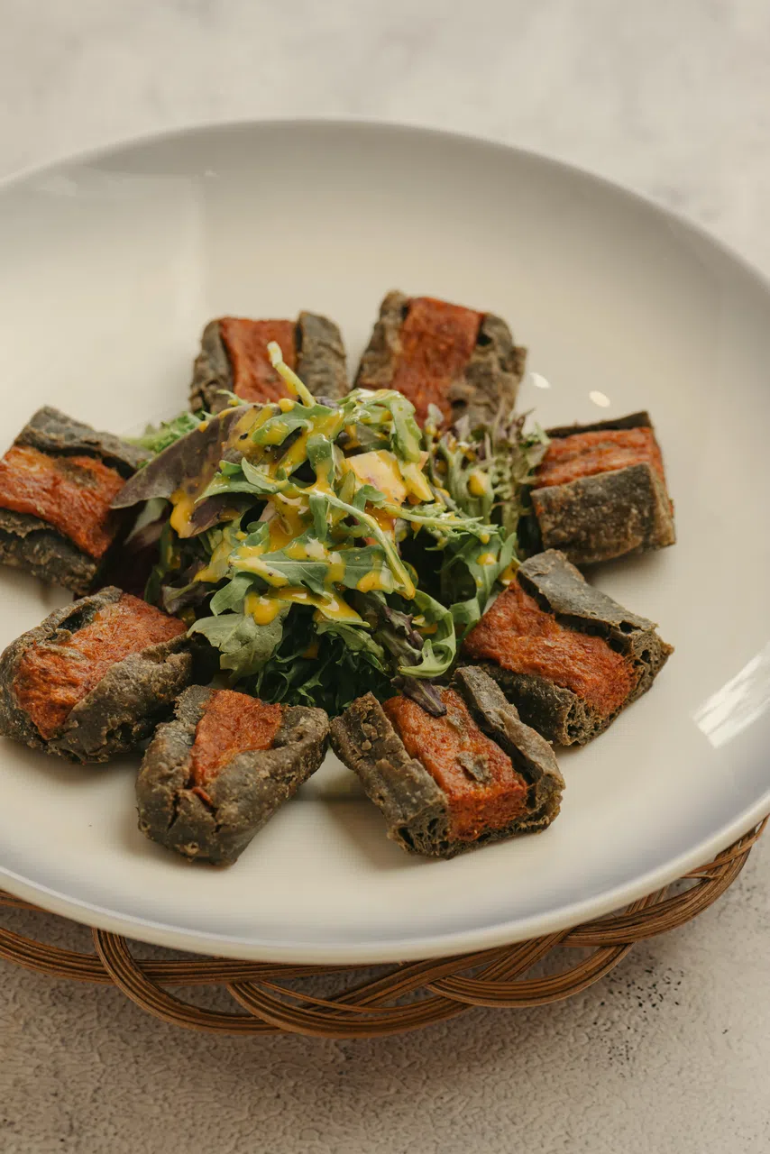 乌达黑炭油条沙拉菜，黑炭油条中裹着乌达馅搭配沙拉菜享用。（餐馆提供）