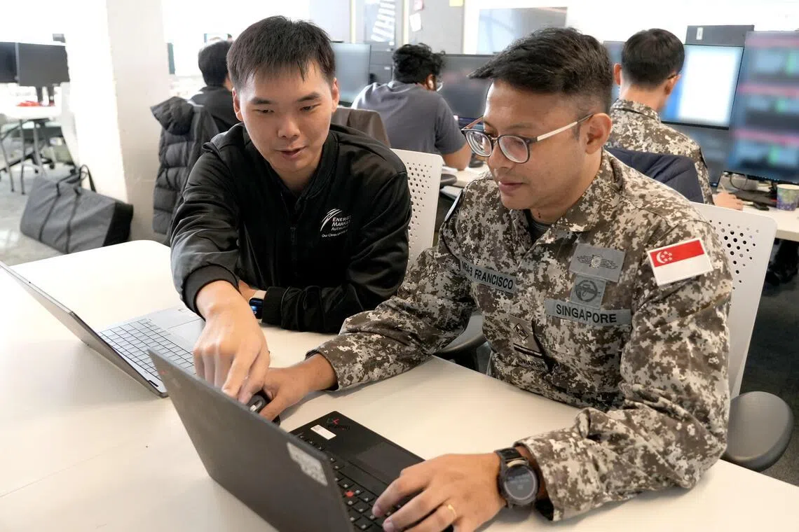 来自能源局和国防数码防卫与情报军部队的参与者，正在应对模拟的网络攻击。（国防部提供）