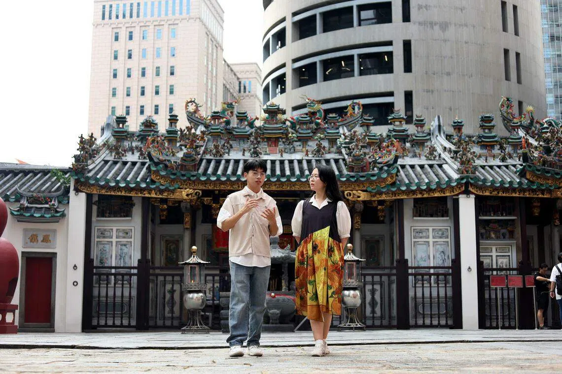 郭一（左）和韩欣楠（右）在粤海清庙中畅谈新加坡常见的庙宇空间。（龙国雄摄）