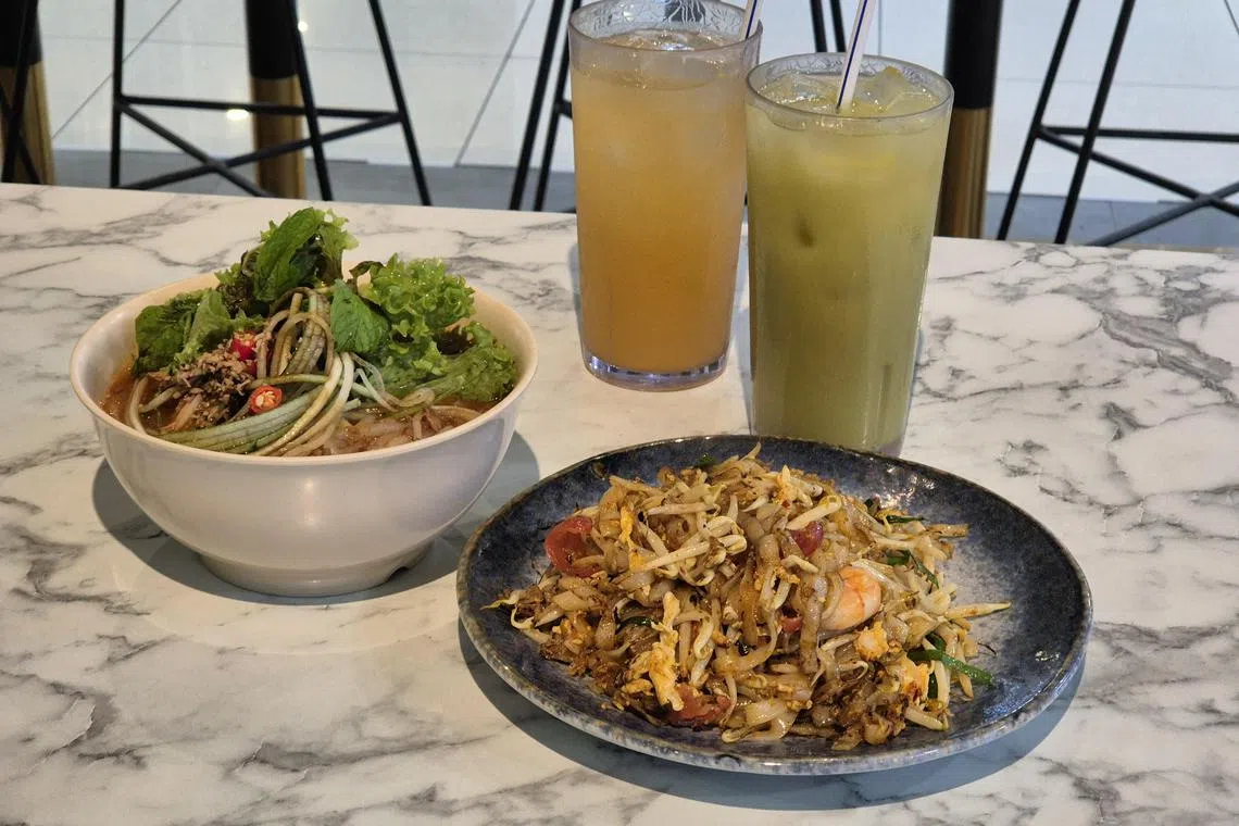 Penang Kitchen的炒粿条和亚参叻沙，配搭沙厘果和豆蔻饮料。（陈爱薇摄）