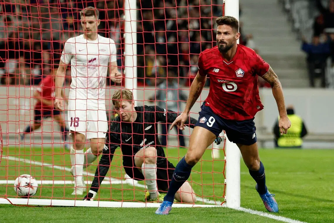 吉鲁（红衣）在比赛末段以一记精彩的头球破门。（路透社）