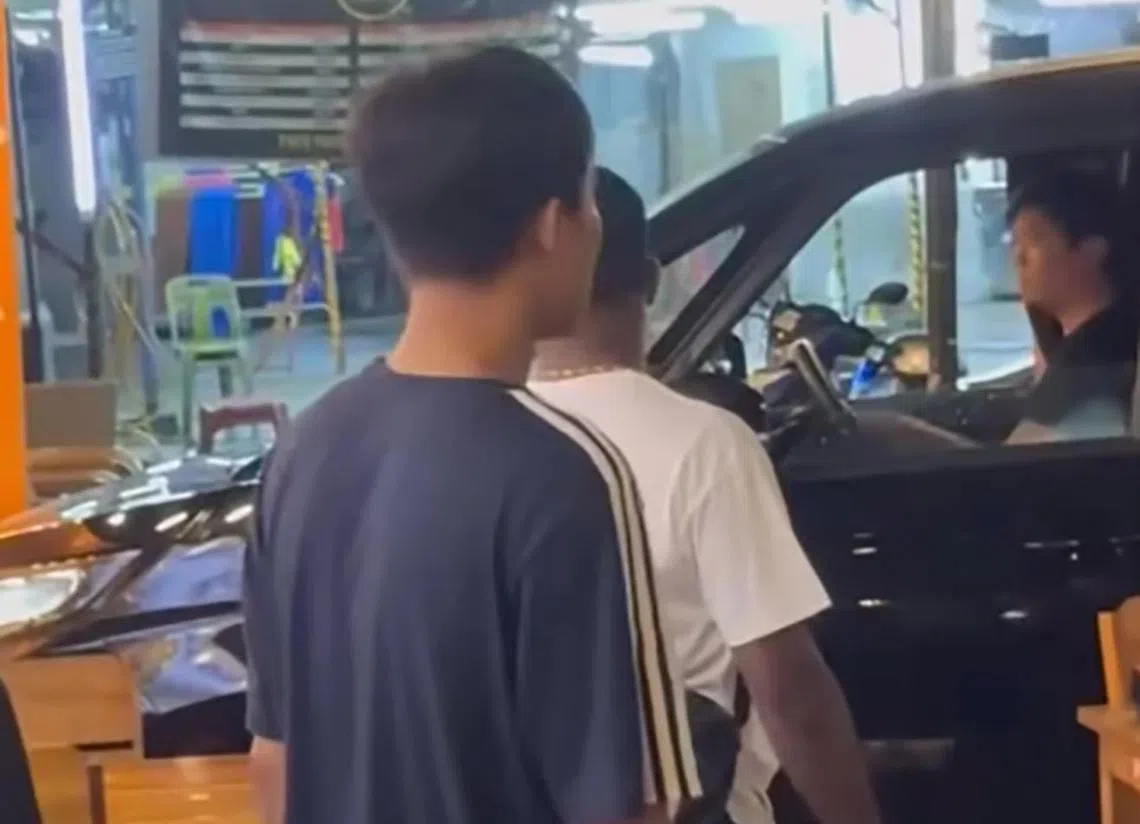 另一名在场的男子协助将汽车驶出店外。（中国报）