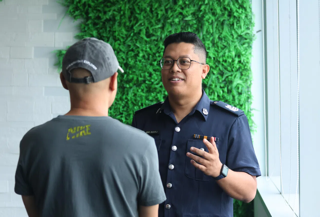 祖基菲里（Mohammed Zulkifli）高级警曹长（右）与60岁受害者一起受访，叙述钱骡的银行户头被用来收取赃款的过程。（梁麒麟摄）
