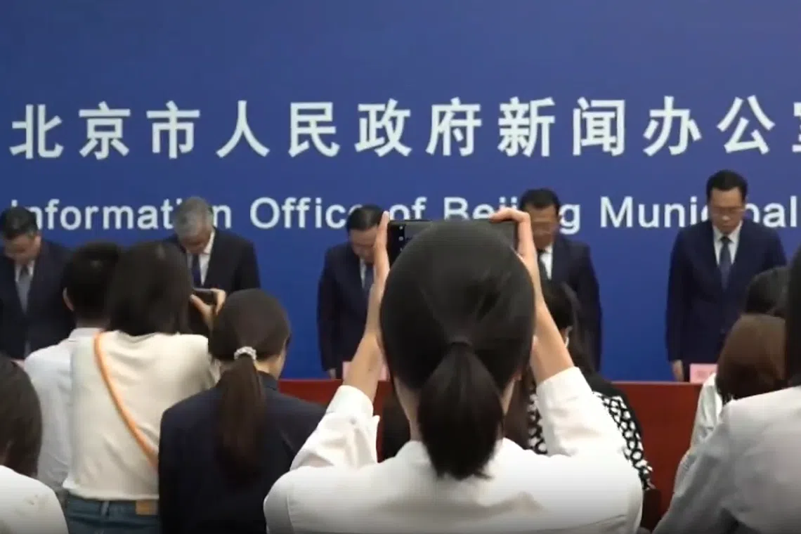 北京市官员星期三（8月9日）在新闻发布会现场全体起立，为遇难者默哀。（视频截图）