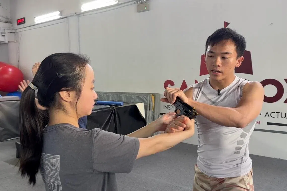 为了配合动作片拍摄需求，吴宇烽（右）也会指导学员学习兼顾视觉效果与操作安全的枪械使用技巧。（萧康达摄）