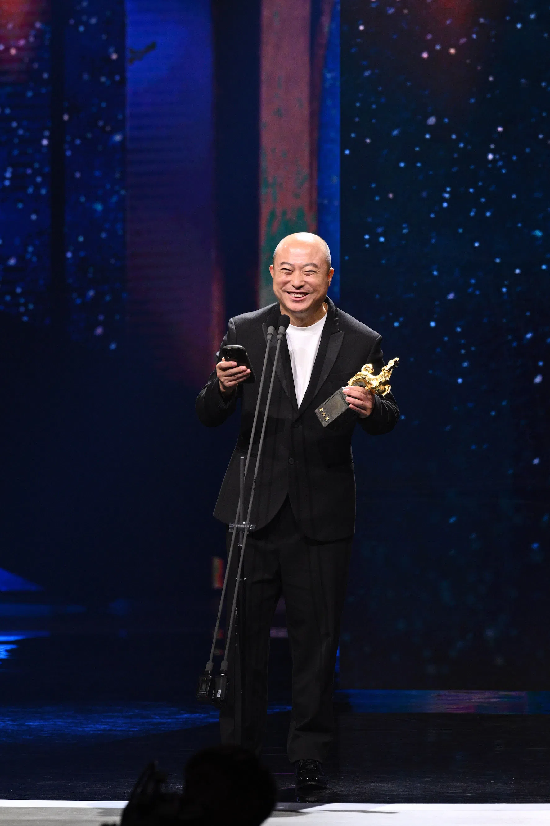 导演耿军代张志勇上台领影帝奖座。（取自金马奖官网）