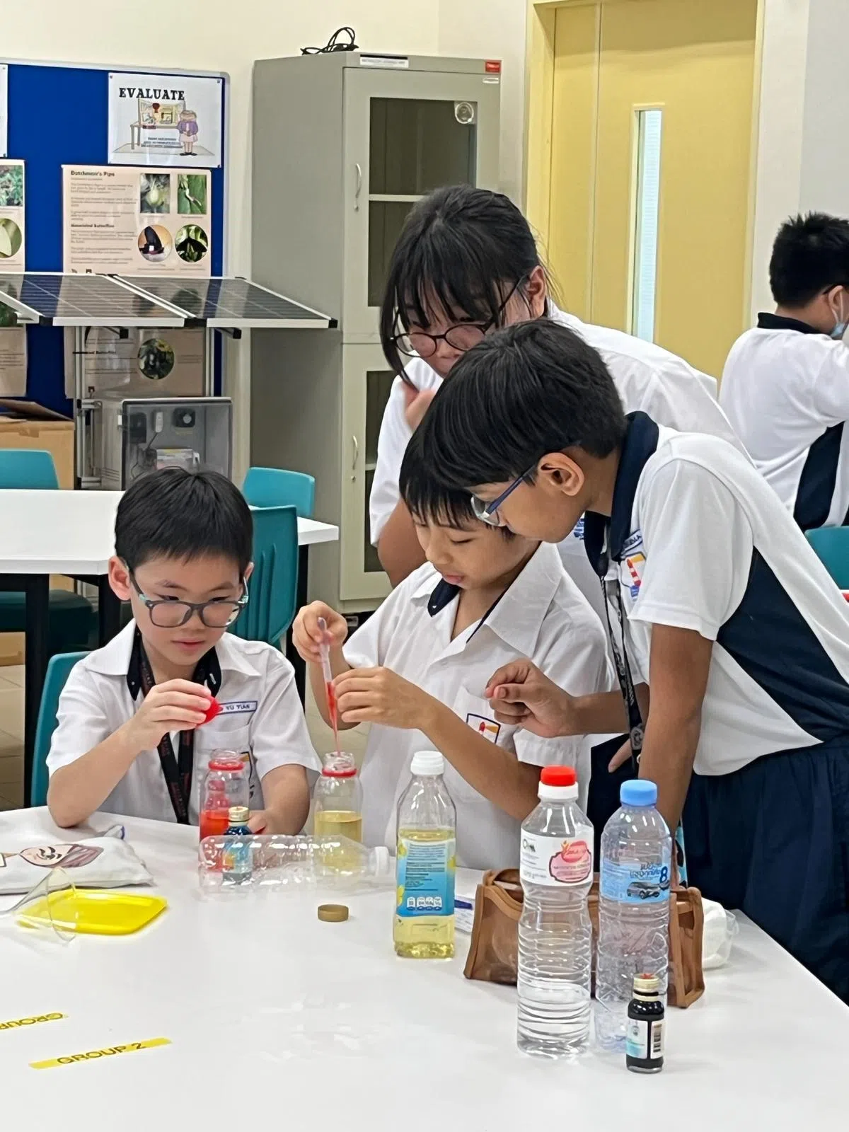 河道小学为能力较强学生开办的增益课平均各有20至30人参加。图为参加E2K科学项目的学生进行实验，探究油和水的特性。（河道小学提供）