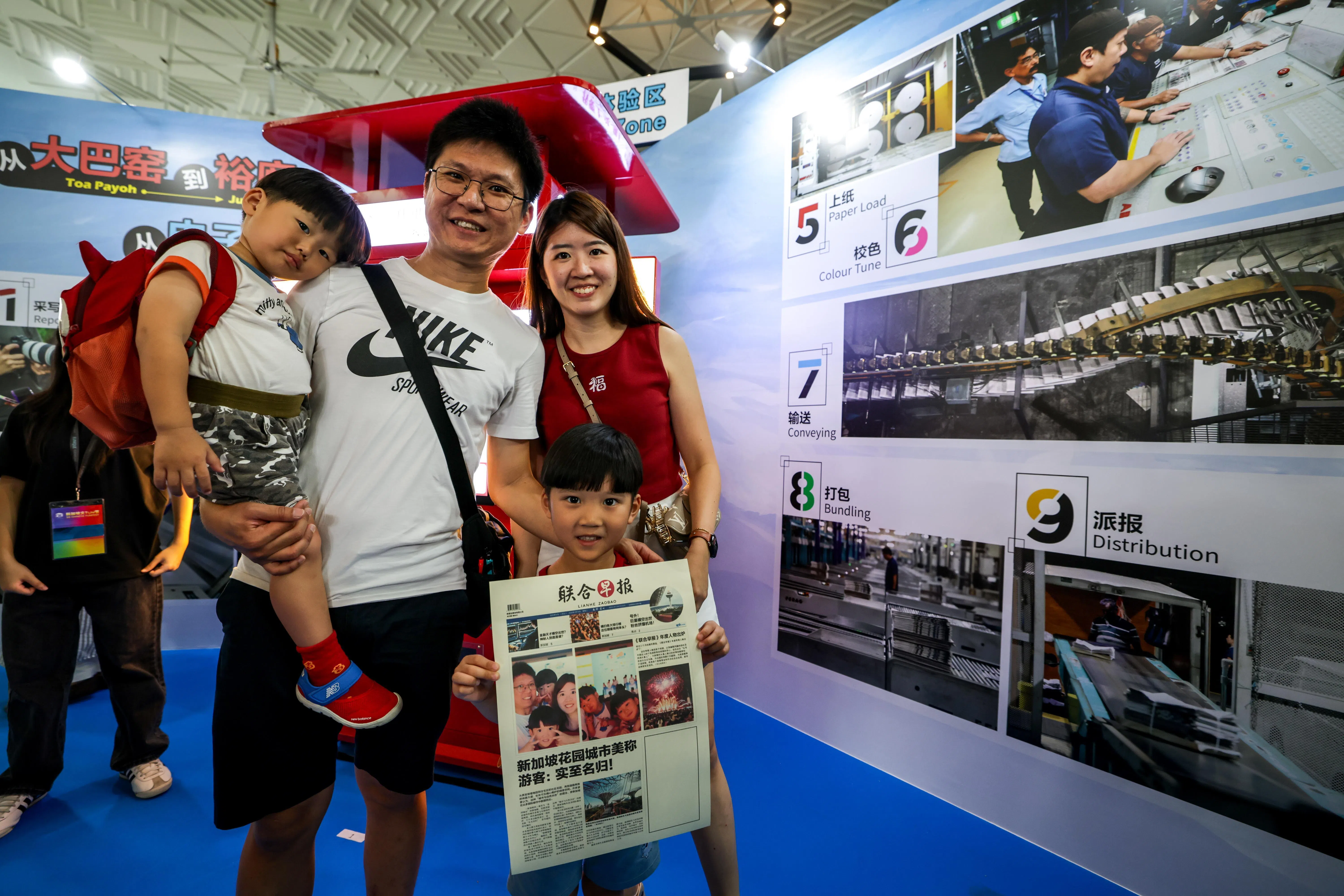 相机拍下照片，一家人马上登上《联合早报》的头条新闻，过个瘾，亲身体验当新闻主角的感觉。（叶振忠摄）