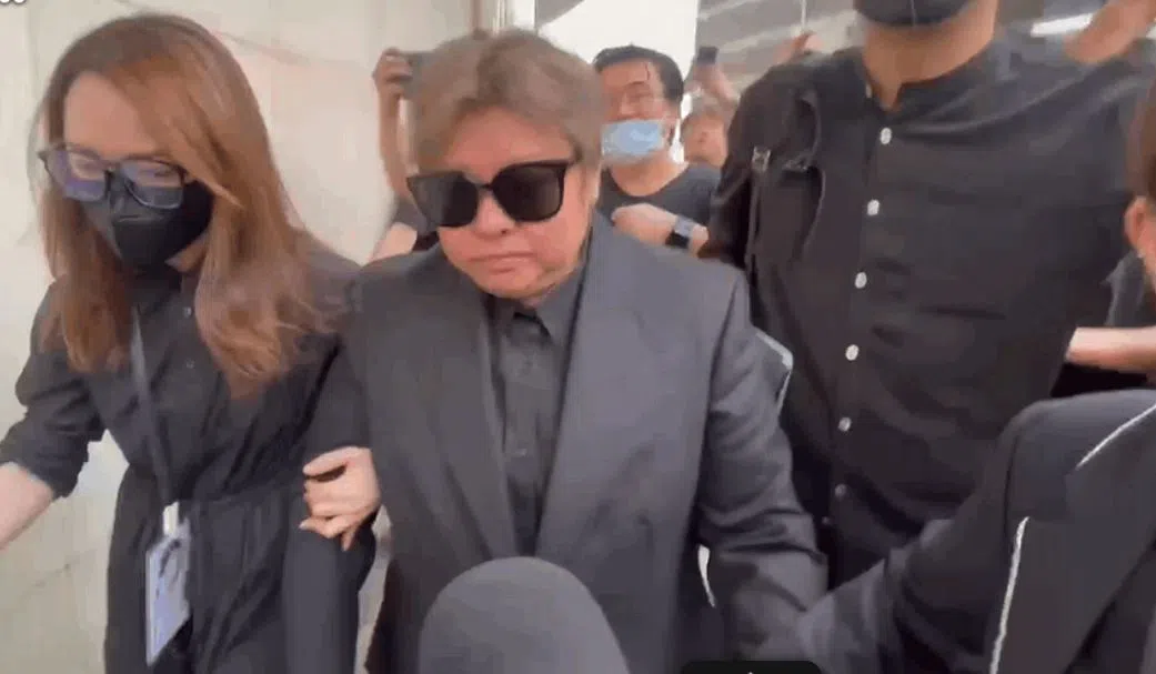 韩红（戴墨镜者）需要人搀扶进入灵堂。（互联网）