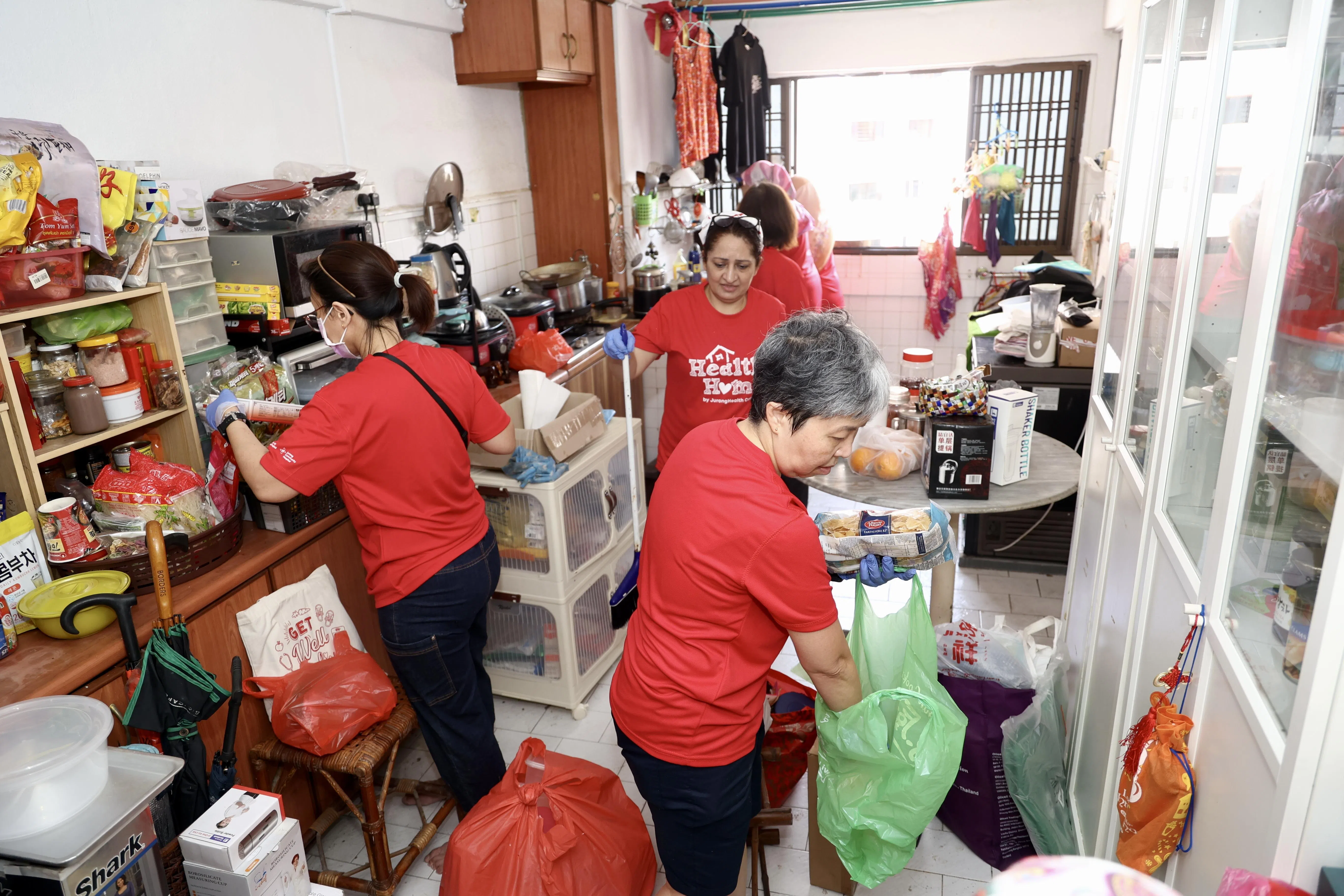 黄廷方医院和裕廊社区医院的义工们帮助弱势家庭进行新年大扫除，包括清洁厨房、处理过期食物等。（郑一鸣摄）