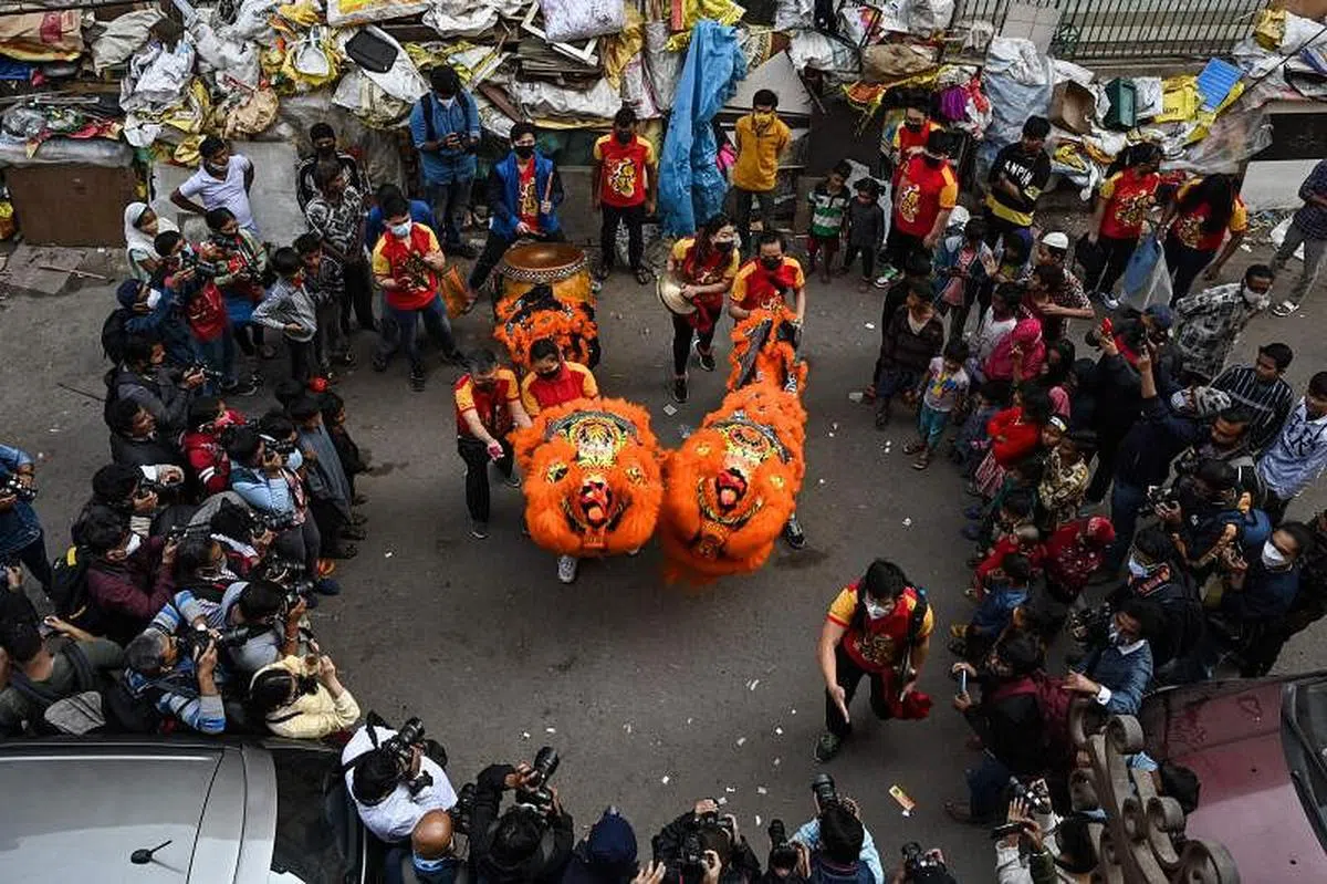 大年初一，加尔各答的唐人街锣鼓喧天，由华人或印度人组成的舞狮团呈献精彩表演，吸引不少民众驻足，共同迎接农历新年。（法新社）