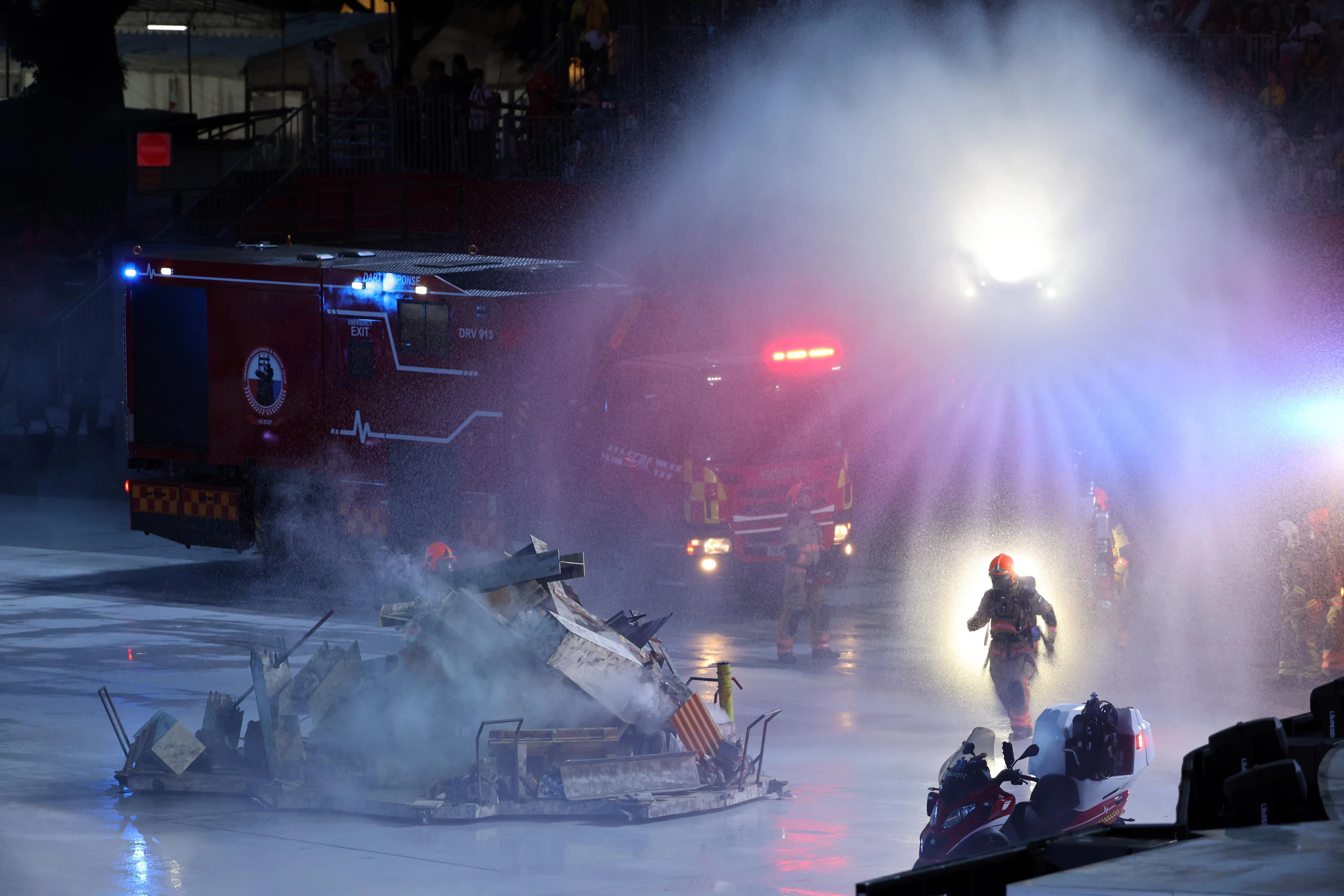 民防部队的无人驾驶灭火机（Unmanned Firefighting Machine）喷出水幕，能有效协助应对大型火患，减少消防员可能面对的风险。（邝启聪摄）