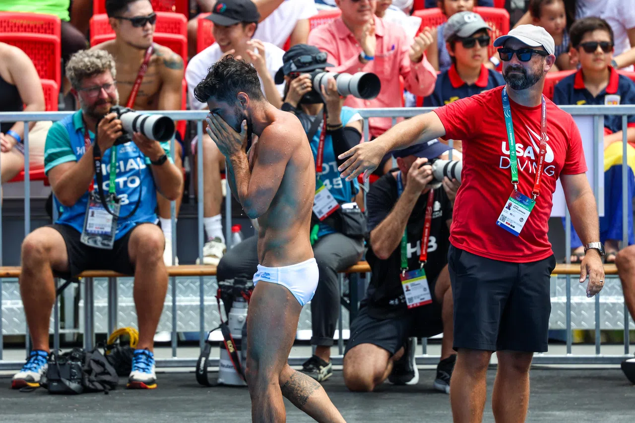 从第二轮预赛后就一直领先的西班牙选手吉梅诺（白泳裤者）因在决赛最后一轮出现失误而痛失金牌，他在赛后难掩失望之情。（关俊威摄）