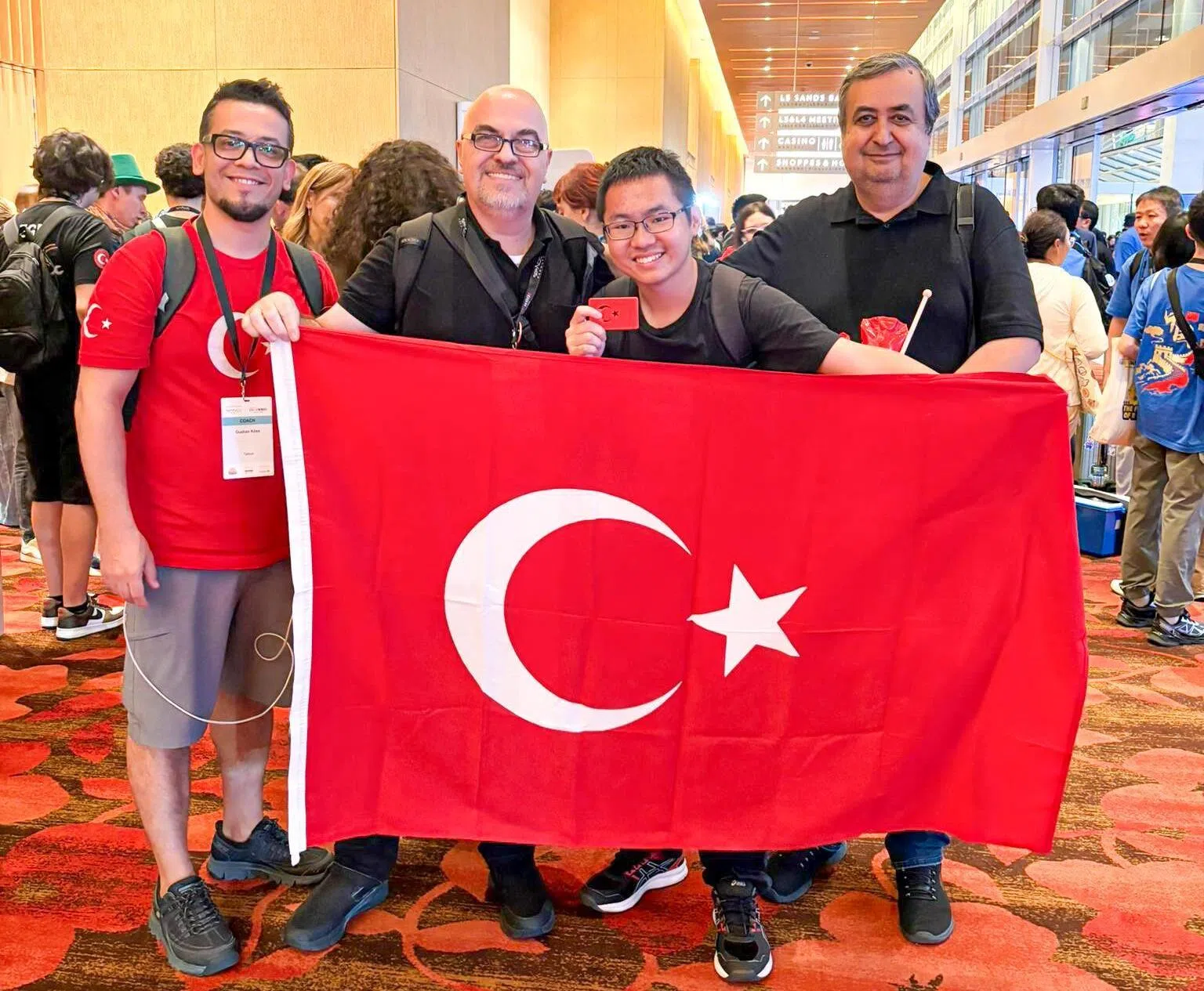 谭骏汉（右二）偶遇一组来新加坡参加机器人竞赛的土耳其代表，双方用土耳其语交流。（受访者提供）