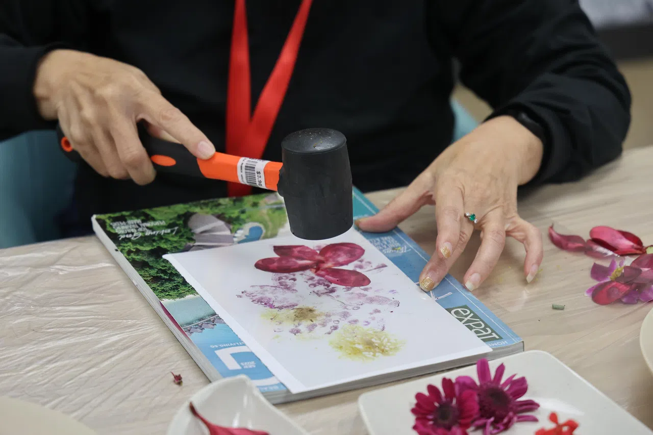 参与者拿起锤子轻轻敲出花朵的鲜艳色彩，能锻炼精细运动技能。（唐家鸿摄）