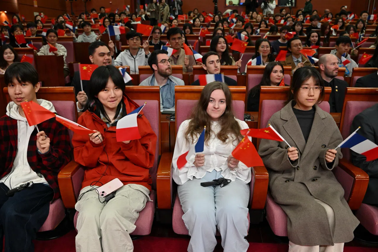 法国外长巴罗3月27日在北京语言大学发表演讲时，学生们举着中法两国国旗。（路透社）