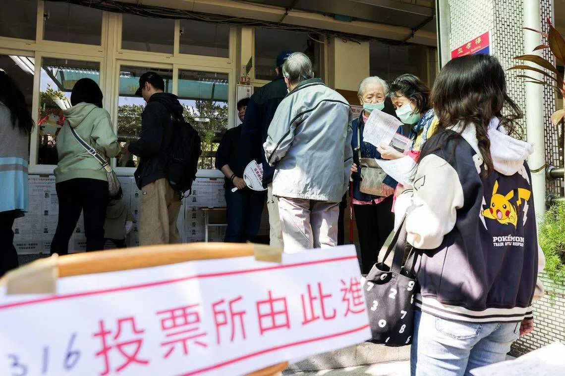 选民在台北市一个投票站排队等待投票。（法新社）