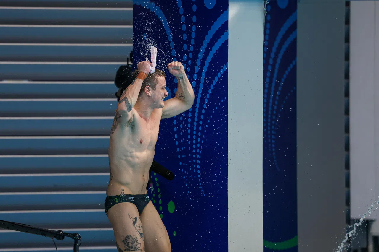 鲁索看到自己的最后一跳分数后，在水池边庆祝位列第一。（关俊威摄）