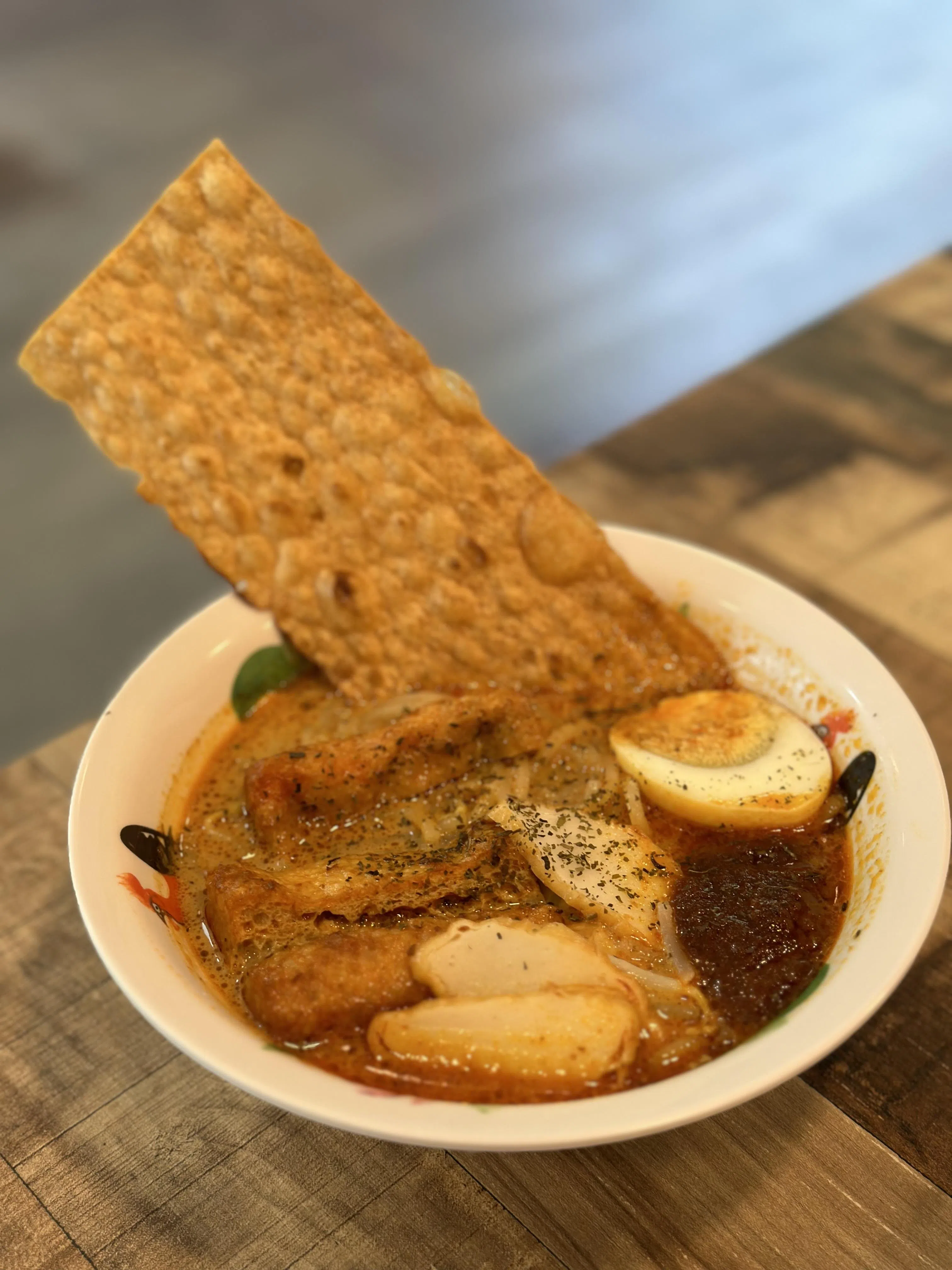 Laksa FaFa，椰浆叻沙汤面里加了鱼饼、豆卜和水煮蛋，搭配烘烤过的鳕鱼香丝，替代传统炸腐皮，口感酥脆富有创意。（叶晓虹摄）