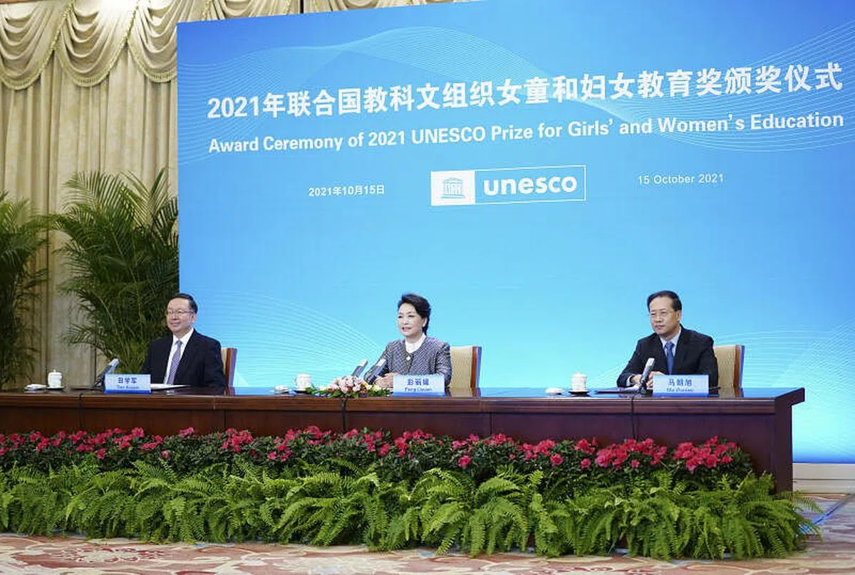彭丽媛（中）10月15日在北京以视频方式出席联合国教科文组织女童和妇女教育奖颁奖仪式。（新华社）