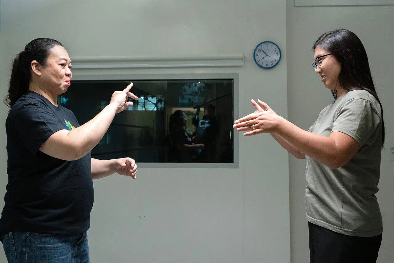 温恩灵（右）试着模仿吴丽丽的手语。（档案照）