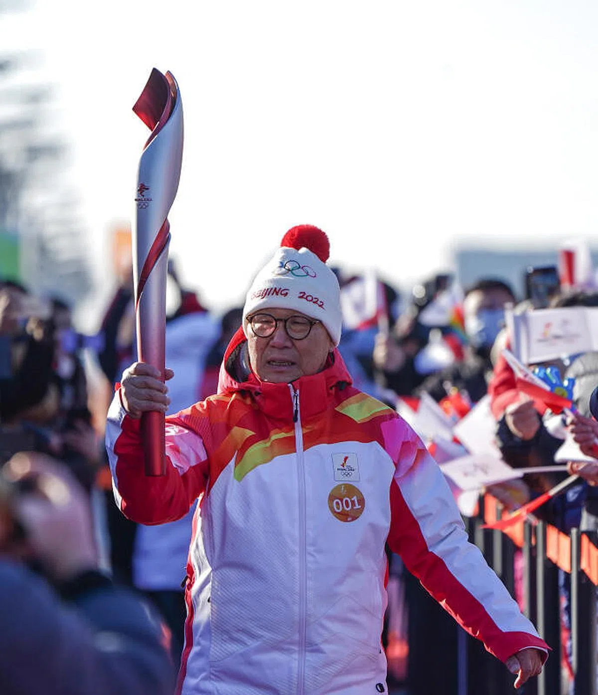 第一棒火炬手罗致焕在火炬传递中。（新华社）