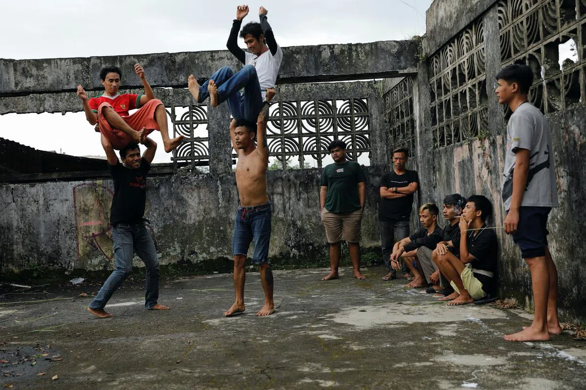 由印尼青年组成，自称为“红白龙狮”的舞狮团，在一个废弃的工厂大楼加紧排练传统舞狮，为新年表演做准备。（路透社）