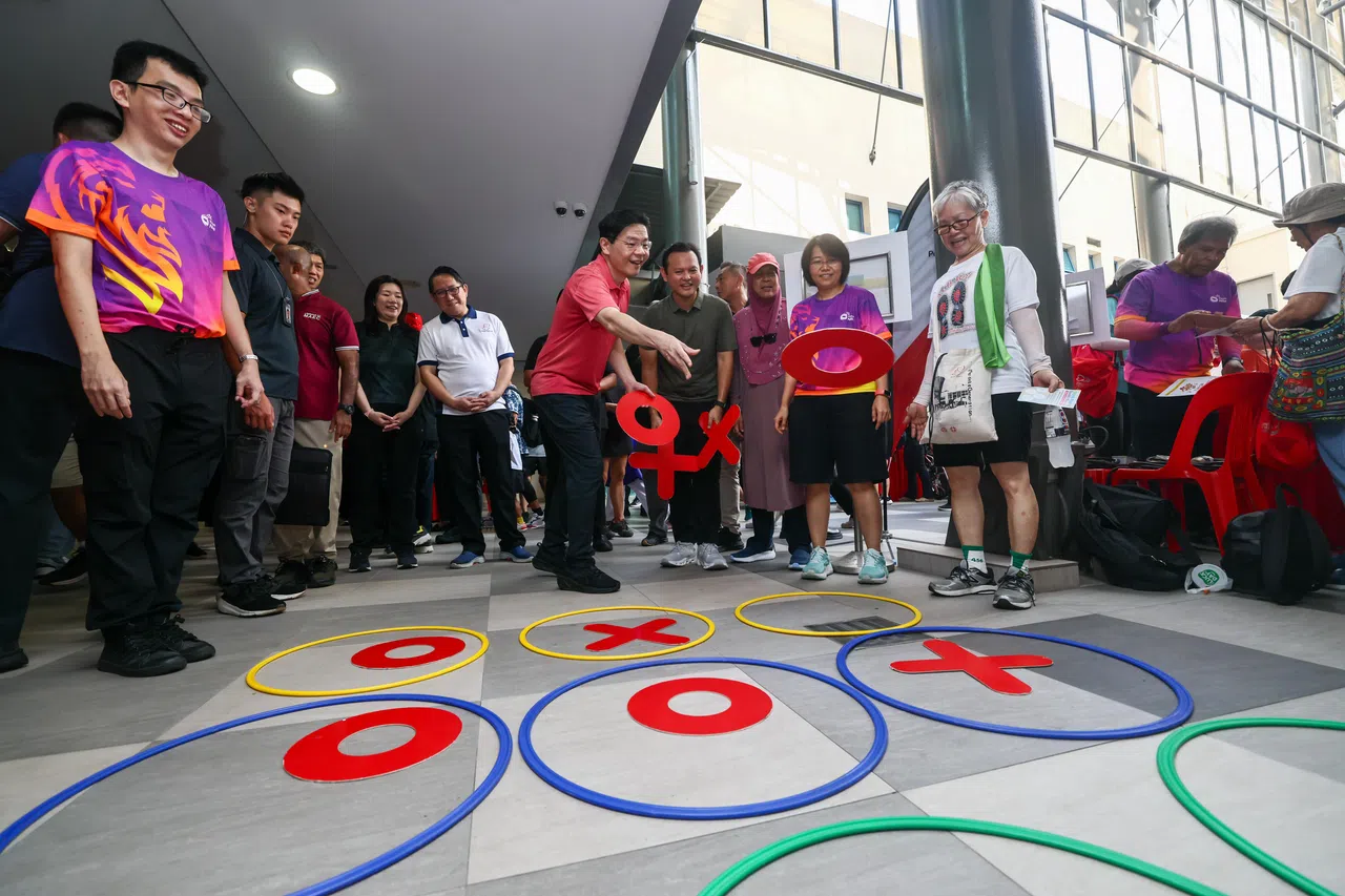 刚结束中国访问行程的黄循财总理（中），星期六也到蔡厝港体育场参与社区活动，与热情民众交流互动。（陈渊庄摄）