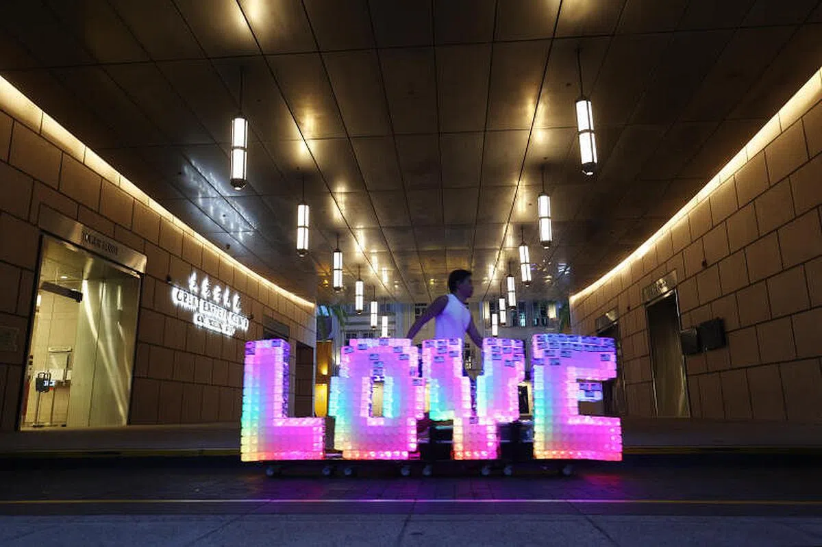 华灯初上，李伟烈推着七彩的“爱”行走，更成为城市一抹动人的移动风景。（蔡家增摄影）