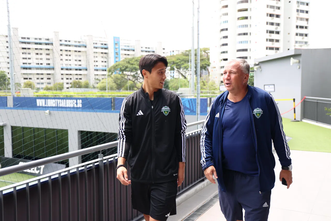 全北现代主帅丹·彼得雷斯库（右）与中场白昇浩一身轻装步入记者会现场。（梁麒麟摄）