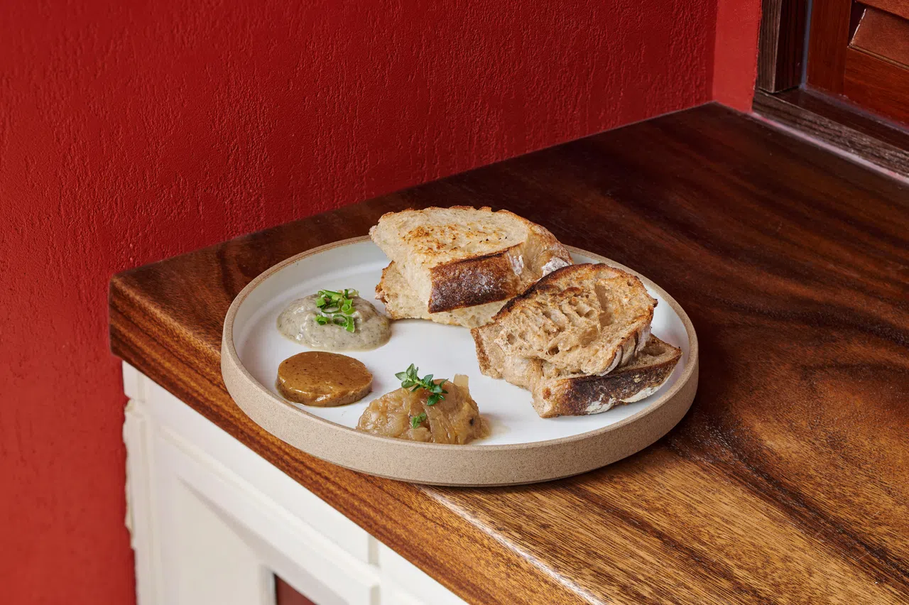 酸种面包拼盘，可搭配黑蒜牛油、焦香韭葱奶油酱及洋葱百里香果酱享用。（餐馆提供）