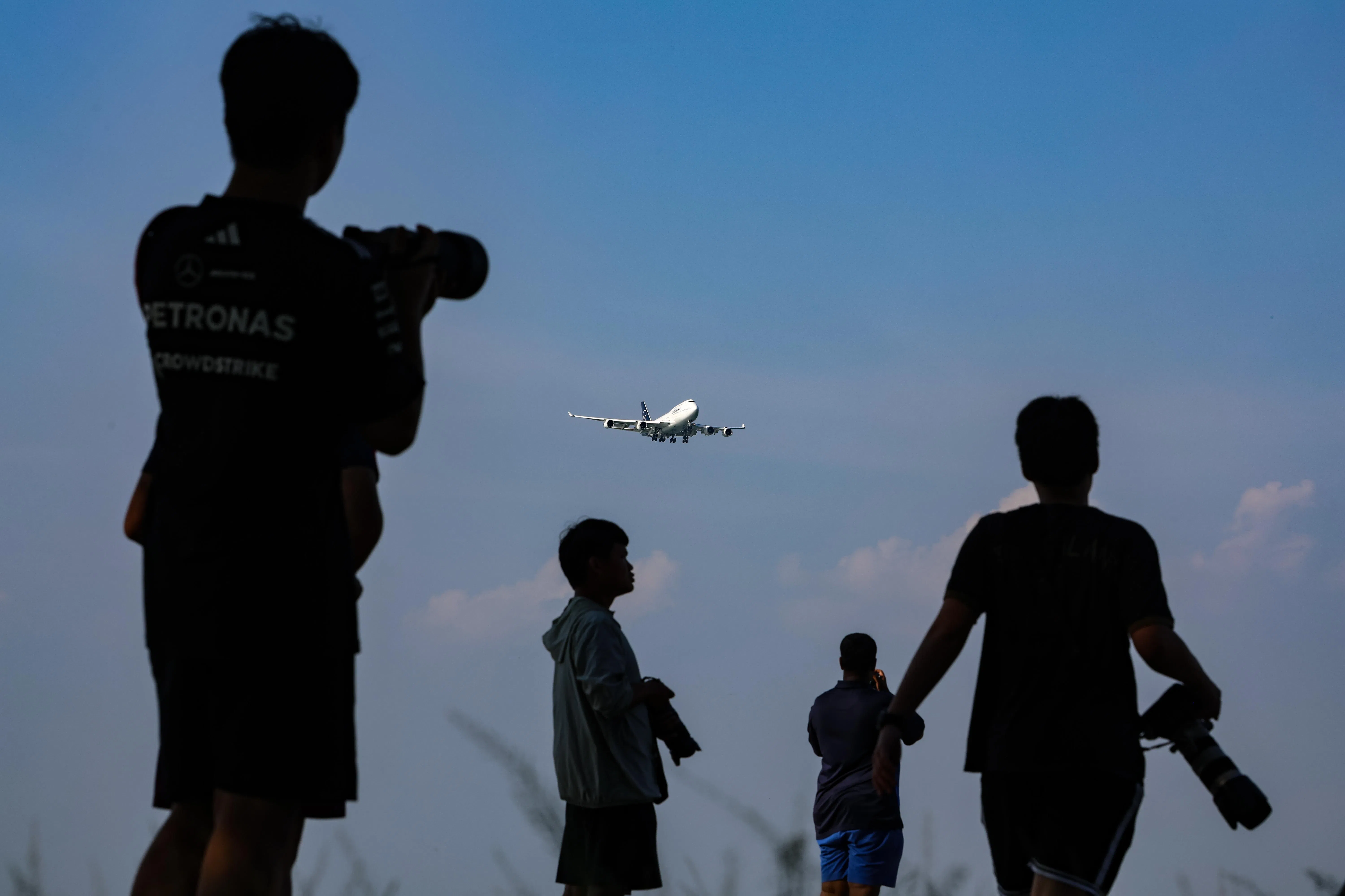 当飞机低飞而过，仰望成为一种共同姿态。（关俊威摄）