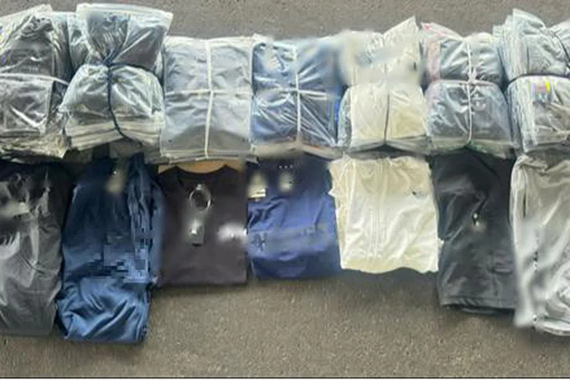 当局在行动中起获超过1万4200件涉嫌侵犯商标的服饰，以及超过14万2000元现金。（新加坡警察部队提供）