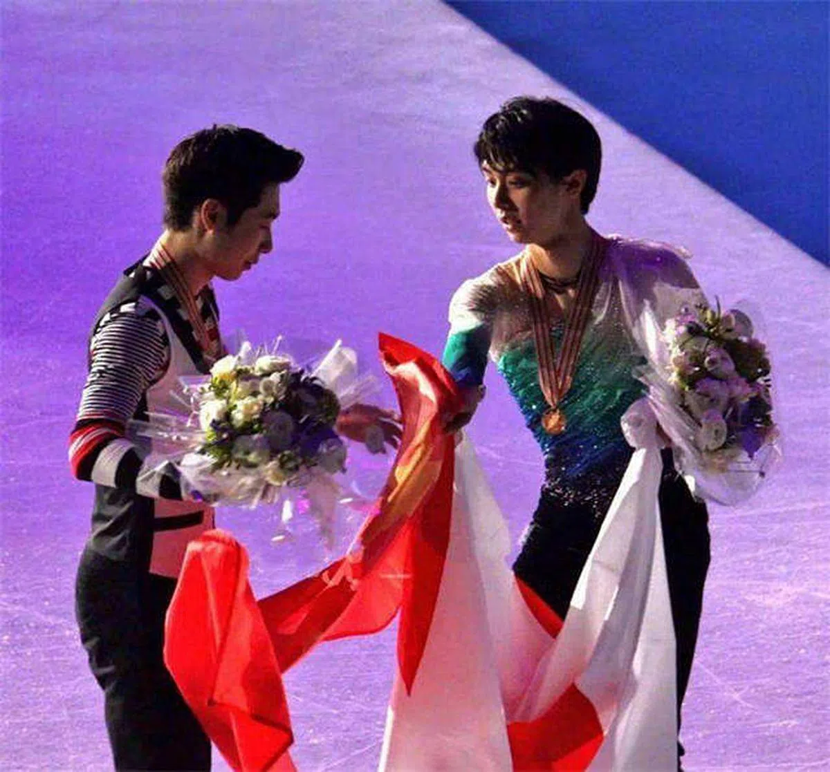2017年赫尔辛基世锦赛颁奖礼上，羽生发现中国选手金博洋举起的国旗在摄影师的角度中是反的。于是滑到他身边，小心翼翼地帮忙摆正中国国旗。（互联网）