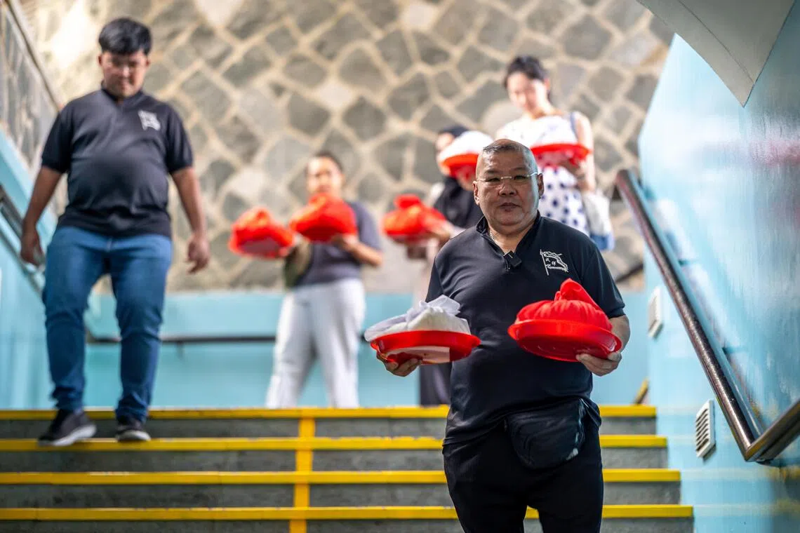 俞肇斌安排三名义工，分别手捧七份骨灰。（叶振忠摄）