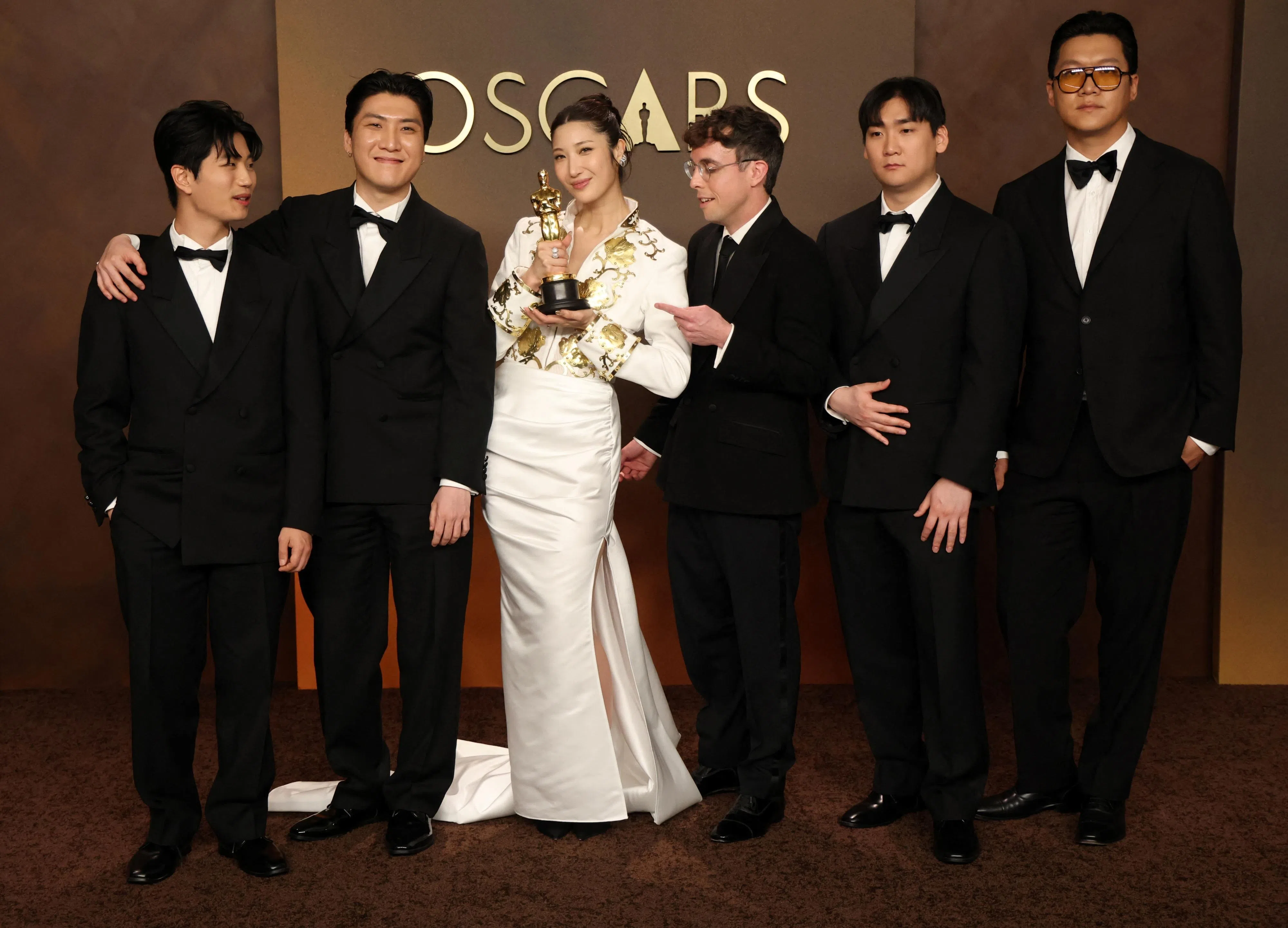 “Golden”的歌手之一Ejae（左三）和其创作团队夺得最佳原创歌曲大奖。（路透社）