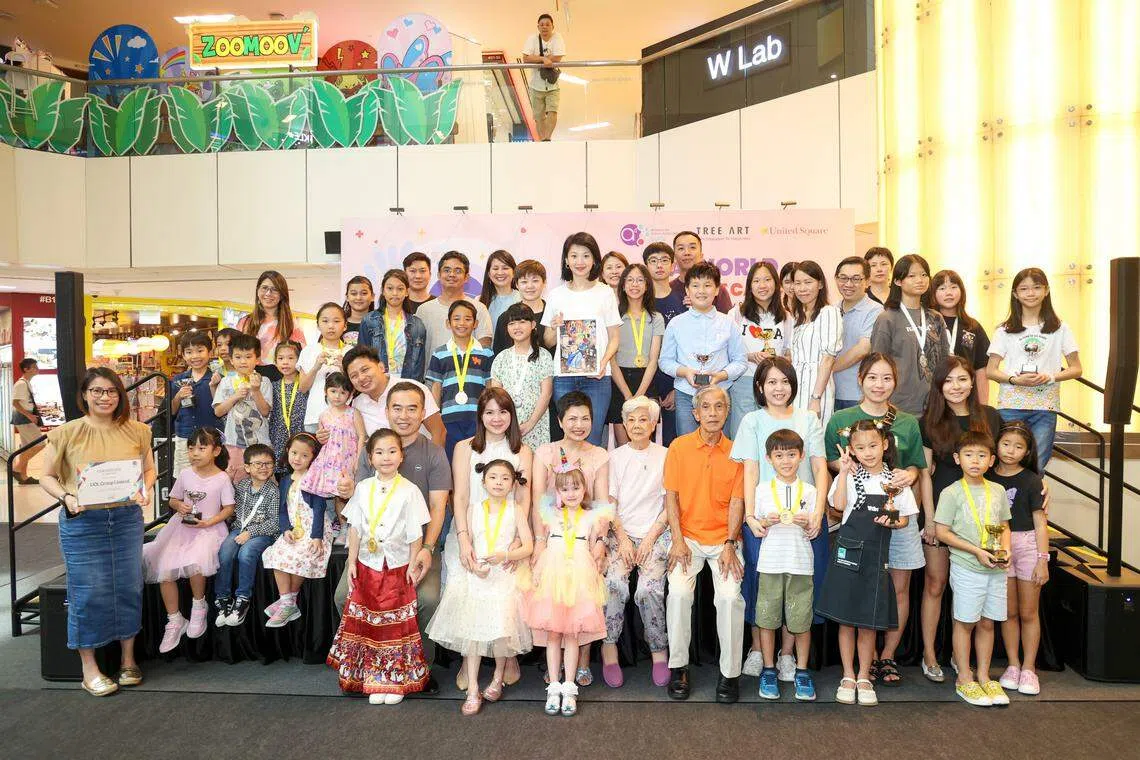 “没有癌症的世界”绘画比赛共收到616份作画，优胜者星期六从内政部兼社会及家庭发展部政务部长孙雪玲（后排中白衣者）手中接过奖状，不少人是全家大小一同出席。（吴先邦摄）