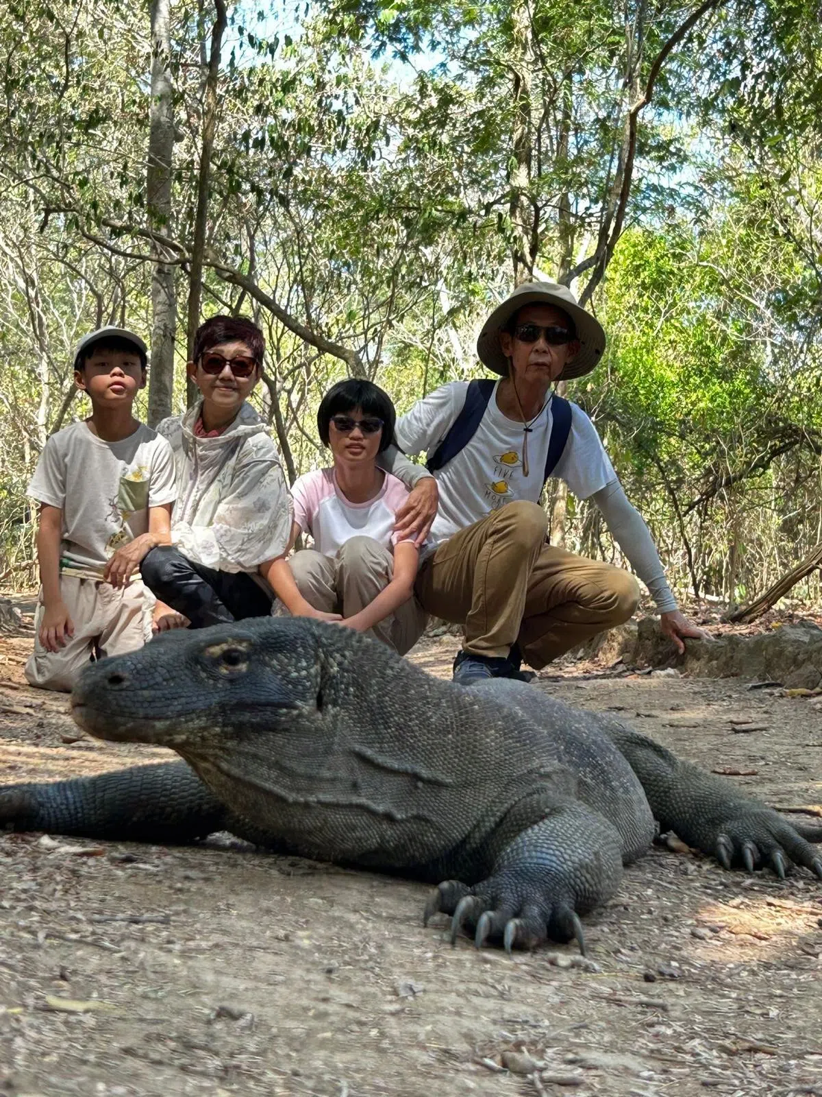 78岁的吕亚伟（右）每年两三次与孩子和孙子一起出国。图为他今年6月，与妻子曾梦娜带着还在就读小学的孙子和孙女一起前往印尼科莫多岛浮潜和寻访世界上最大的蜥蜴科莫多巨蜥。（受访者提供）