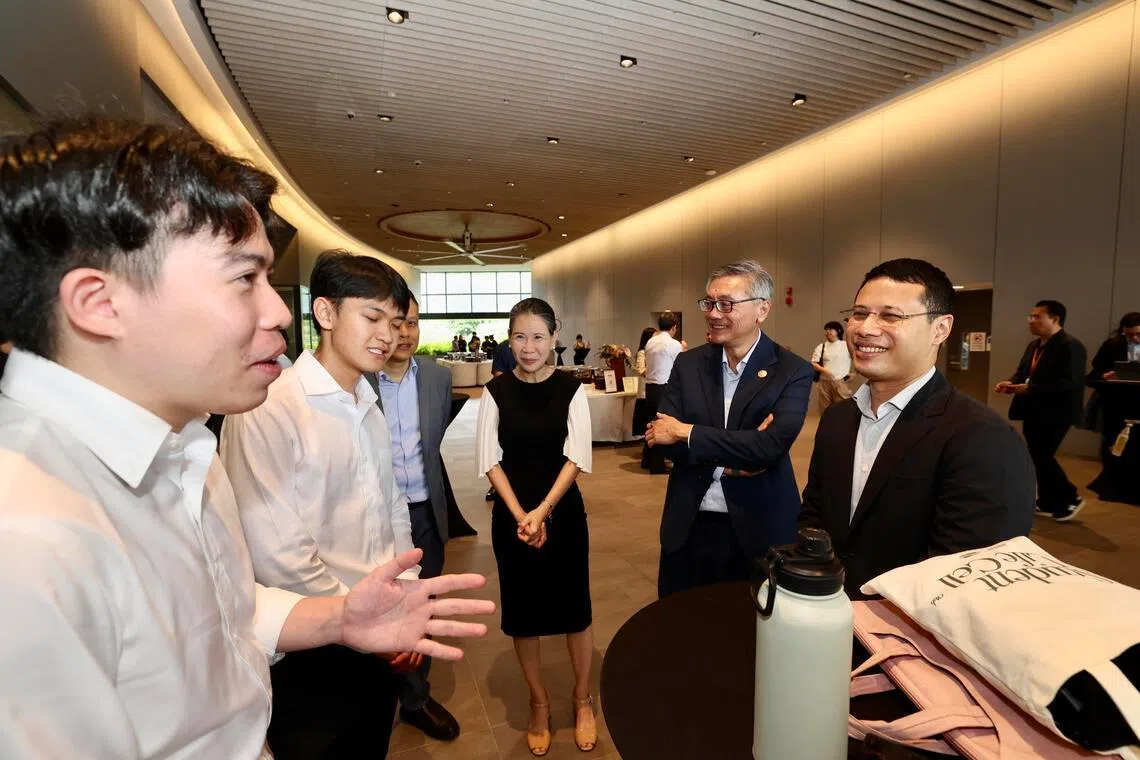 教育部长李智陞（右一）星期四在国大发表杰出人士系列演讲和出席同师生的对话会后，与现场学生交流。右二为国大校长陈永财教授。（邝启聪摄）
