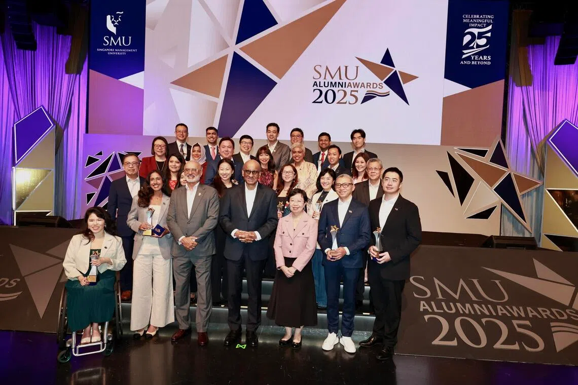 11月12日，总统尚达曼（前排中）、新大董事会主席高博德（前排左三）、新大校长江莉莉（前排右三）和新大首届22位杰出校友奖得主合影。（周国威摄）