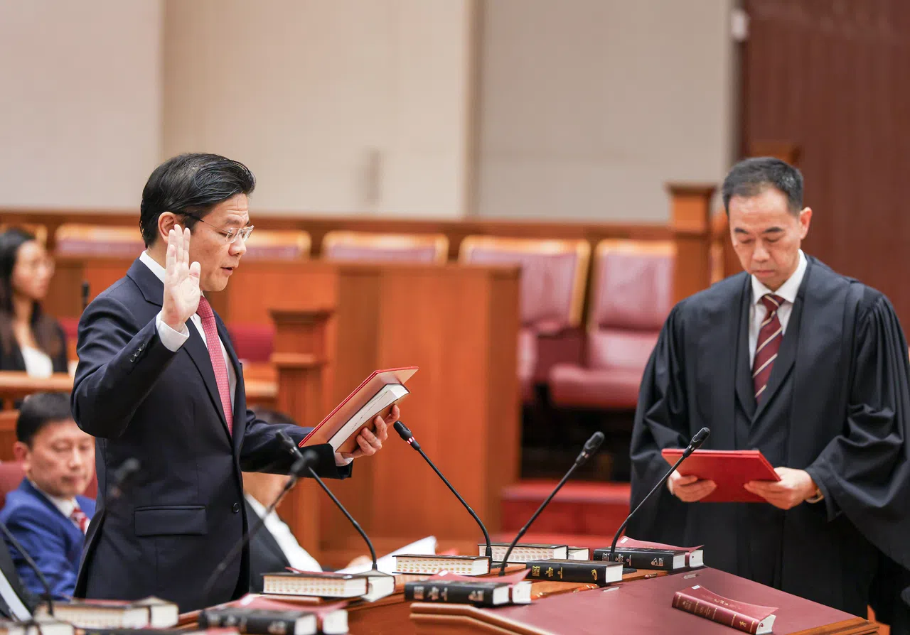 第15届国会星期五下午5时正式开幕，全体朝野议员推举新一任议长，随后宣誓就职。首个宣誓的是我国总理兼财政部长黄循财（左）。（数码发展及新闻部提供）